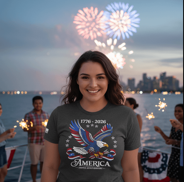 People celebrating with fireworks wearing an America 250 1776–2026 patriotic eagle shirt near a waterfront at night