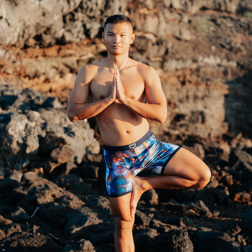 Men's pouch underwear modeled by a man in a yoga pose against a rocky background, showcasing comfort and style.