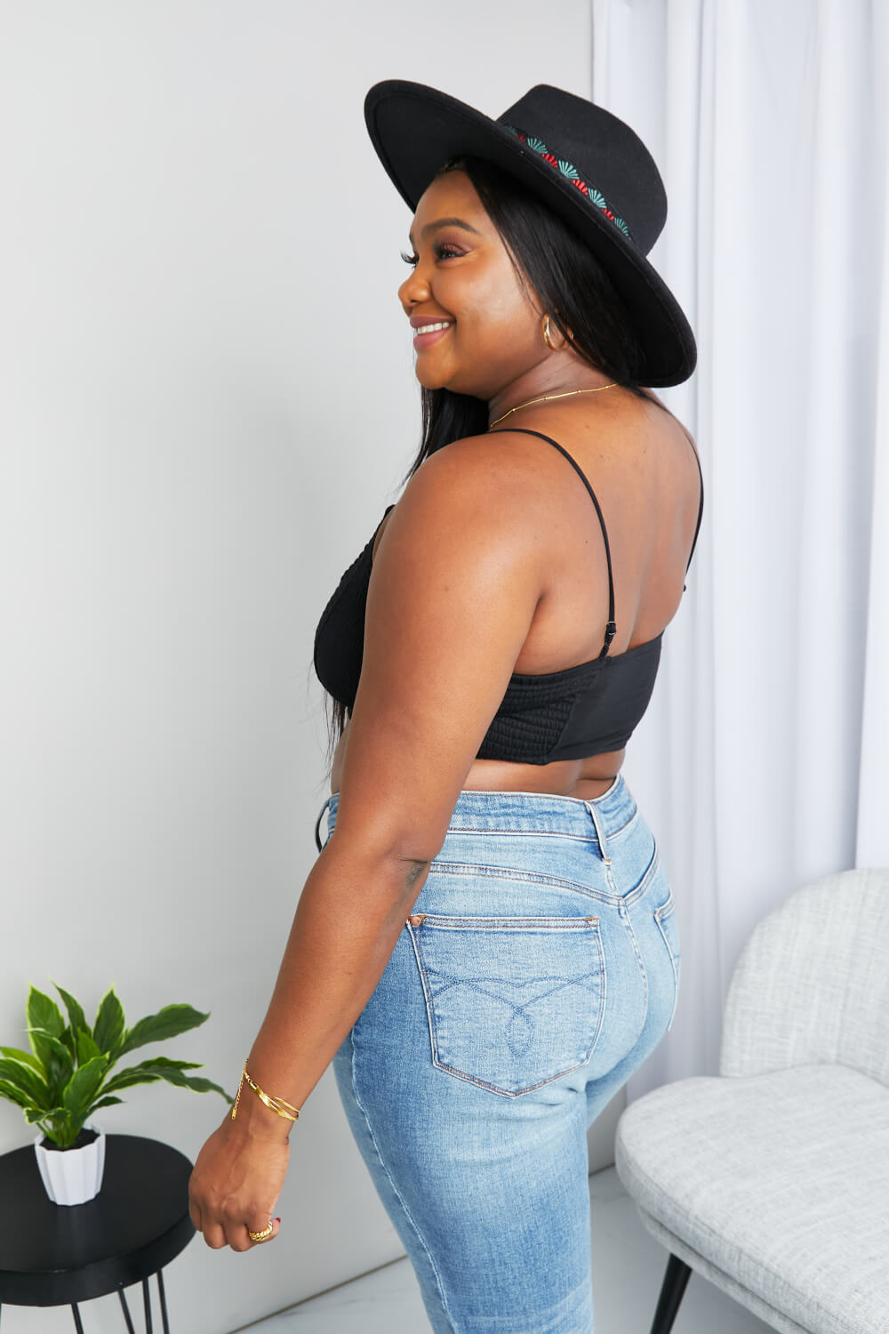 Side view of model wearing Zenana textured spaghetti strap bralette in black — lifestyle angle