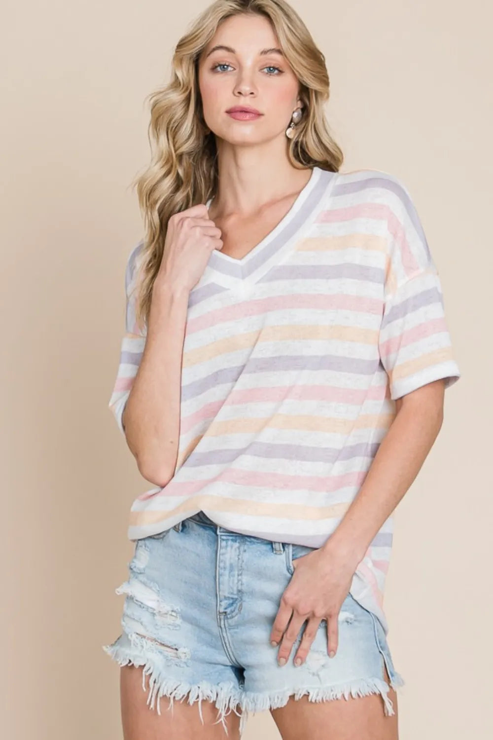 Model gently pulling the V‑neckline of striped short sleeve T‑shirt for detail view
