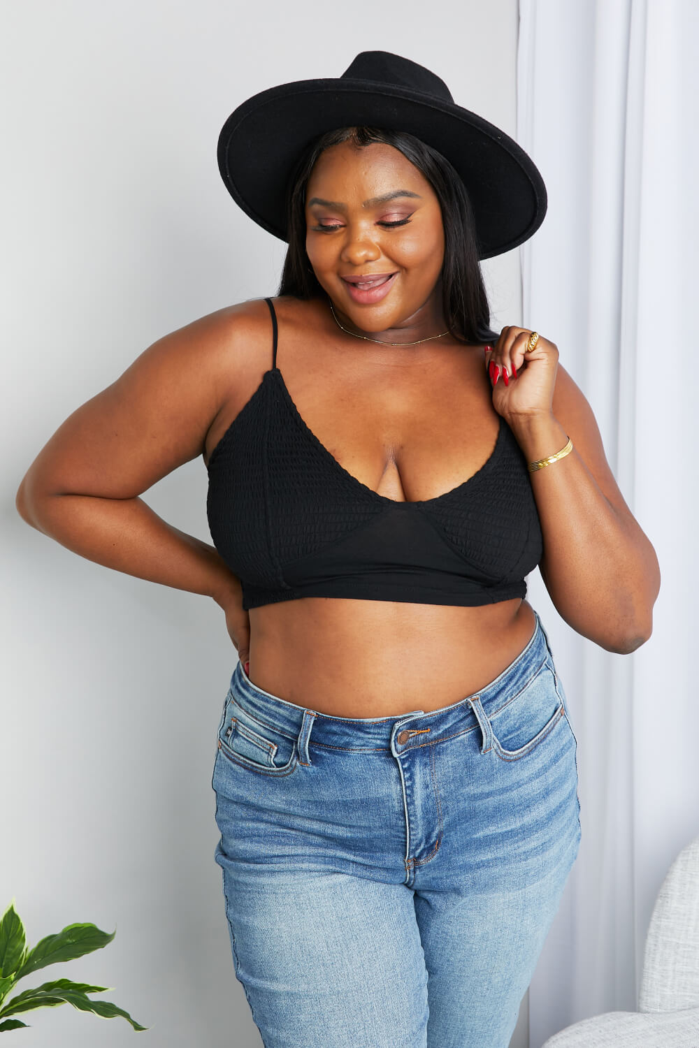 Model wearing Zenana textured spaghetti strap bralette in black — lifestyle back view