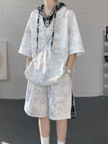 Men's Plus Size Tie-Dye Plaid Patchwork Hoodie and Shorts Set on a model in a stylish indoor setting.