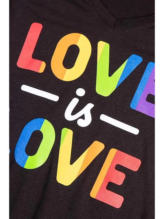 Close‑up of Love Is Love rainbow text graphic on black T‑shirt
